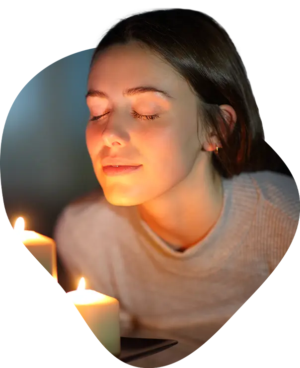 Image of a woman holding a candle, smiling.