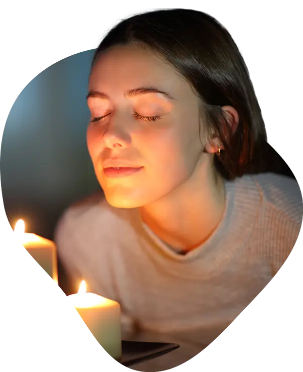 Image of a woman holding a candle, smiling.